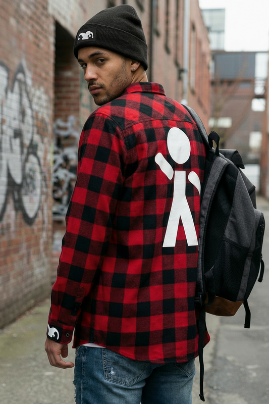 Person wearing a red and black checkered shirt with a white logo on the back, standing in an urban setting.